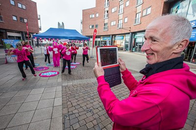 'Cancer Slam' at Eagles Meadow to promote the Race for Life. David Mann videos his wife Jane as she starts another Zumba session