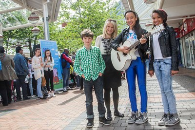 Love Wirral Festival at the Pyramids Shopping Centre, Birkenhead. Singer Tabitha Jade, with drummer Seth Beard and backing singer Eliza Mai with local MP Esther McVey
