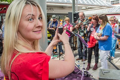 Love Wirral Festival at the Pyramids Shopping Centre, Birkenhead. Proud daughter Lisa Luscombe takes a picture of her her mum Pat Ross, right in blue shirt, playing in the Wirral Ukelel Orchestra.