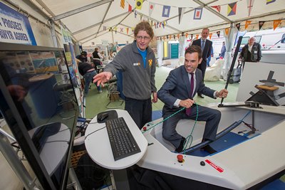 All Wales Boat Show at Conwy. Ken Skates Deputy Minister for Skills and Technology at the Boat Show tries the sailing simulator with some help from Taffy Osborne of Colwyn Bay water Sports..