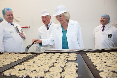 ROYAL VISIT TO VILLAGE BAKERY WREXHAM. ROYAL VISIT TO VILLAGE BAKERY WREXHAM. Pictured is The prince of Wales and the Dutchess of Cornwall flipping Welsh cakes watched by Rob Glover production Manager and Christien Jones .